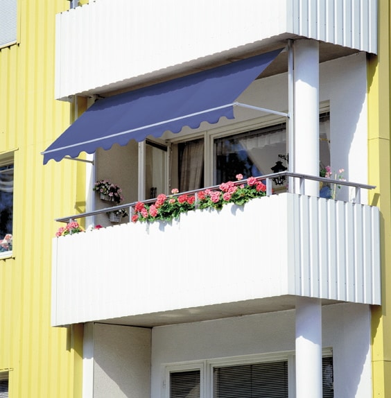 Blå markis på en vit balkong i en gul byggnad.