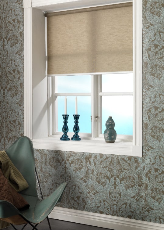 Brun rullgardin i rum med mönstertapet.